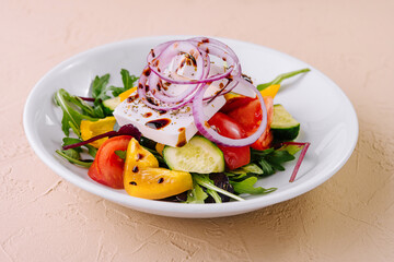 Fresh greek salad with feta cheese and vegetables on a white plate