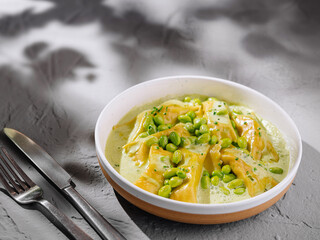 Fresh ravioli pasta with green pea sauce
