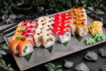 Assorted sushi platter on dark stone background