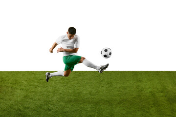 Dynamic photo of young athlete man, soccer player training to kicking ball in motion on green field...