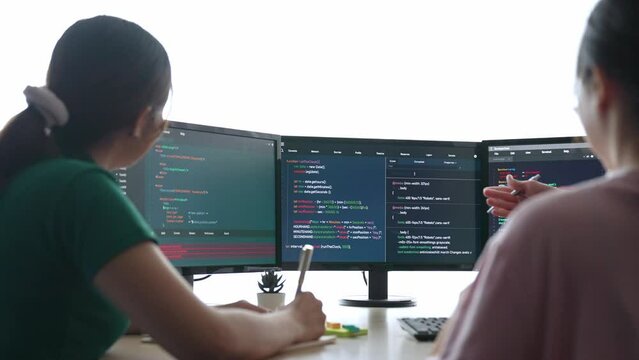 Slow motion back end software developer engineer for computer programming working together on debugging writing computing code, solving complex algorithms display on monitor in office. Burgeoning