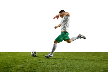 Dynamic image of young footballer prepares to strike soccer ball on lush green pitch against white...