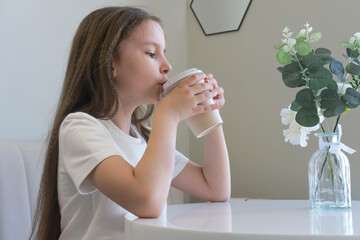 Happy carefree child on vacation enjoying cup of hot chocolate, cocoa, milkshake in cafe. Selective focus.