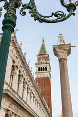Obraz premium Historic clocktower and ornate street lamps overlooking a town square in Italy.