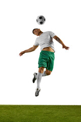 Young man, soccer player jumps in mid-air prepares to head soccer ball, with his body twisted in...