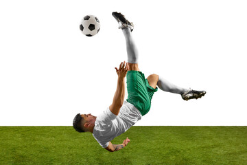 Footballer performing dramatic overhead kick, with his body upside down and ball in motion against...