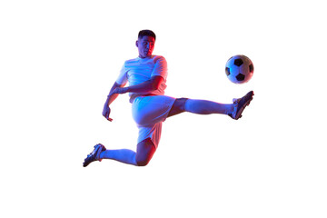 Dynamic portrait of young man, professional soccer player make perfect pass in mid-air in neon light against white studio background. Concept of professionals sport, competition, tournament, action.