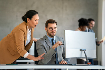 Happy businesspeople laughing while collaborating on a new project in an office.