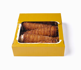 Fresh baked churros in a box on white background