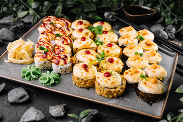 Delicious assorted sushi platter on dark stone background