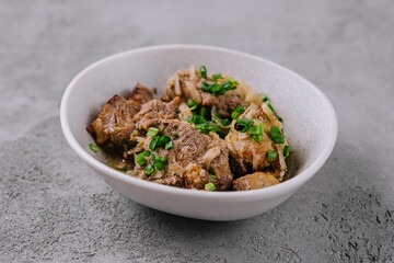 Savory braised beef dish with scallions