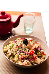 Traditional Moroccan dish - Tabbouleh salad. Tabouli salad with fresh parsley, onions, tomatoes, bulgur and chickpea. Healthy vegetarian food.