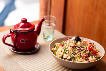Traditional Moroccan dish - Tabbouleh salad. Tabouli salad with fresh parsley, onions, tomatoes, bulgur and chickpea. Healthy vegetarian food.