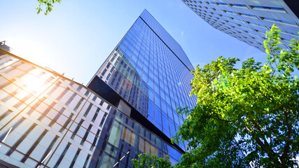 Sustainable glass office building with trees for reducing carbon dioxide. Eco-friendly building in modern city. Office with green environment. Corporate building reduce CO2.