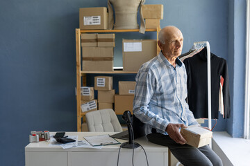 businessman sitting on table holds a customer s parcel in his hands. Delivery and ordering