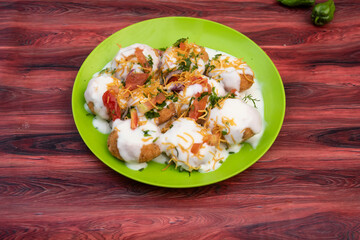 Doi Fuchka, pan puri, or gol gappa filled with herbs with spicy water served in plate isolated on wooden table side view of bangladeshi street food © Food Shop