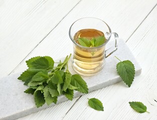 A glass of fresh tea from Melissa officinalis plant, commonly known as balm or melissa. Balm tea is used to calm the nerves and for good sleep in traditional medicine .