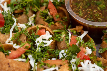 Fuchka, pan puri, or gol gappa filled with herbs with spicy water served in plate isolated on wooden table closeup side view of bangladeshi street food © Food Shop