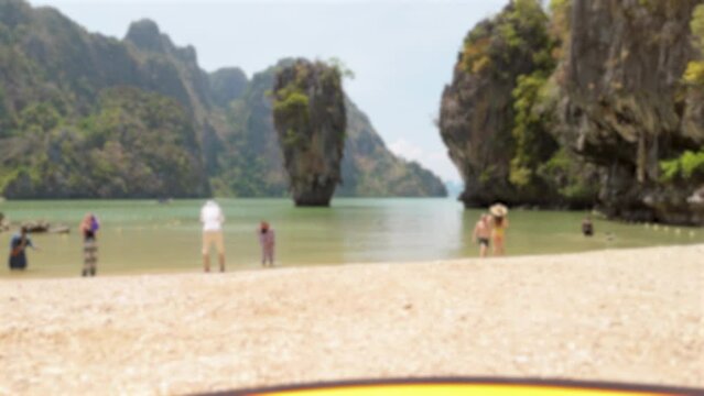 family walking on the beach, Kao Tapu, a cafe on the famous of Kao ping Kan, also known as James bond Island in Phang nga Bay, Thailand with blurred background