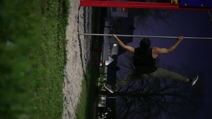 Impressive gymnastics skills on a bar in a park, with handstands, pullups, and tricks. The video also features night scenes of the man doing pullups on the bar