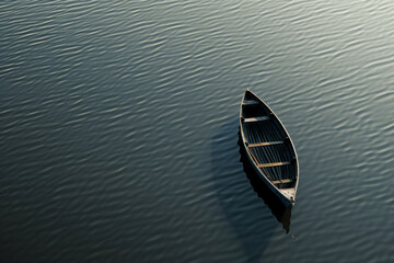 Aerial view of a single boat floating on a calm, open body of water. Highlight the solitude and...
