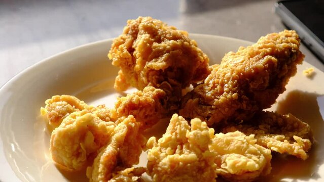 chicken fried wings and drumsticks on white plate in close-up