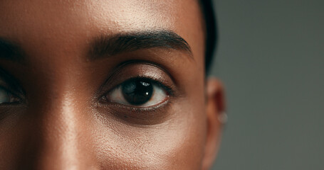 Eye, beauty and skincare with a woman on a gray background in studio closeup for cosmetics. Face,...