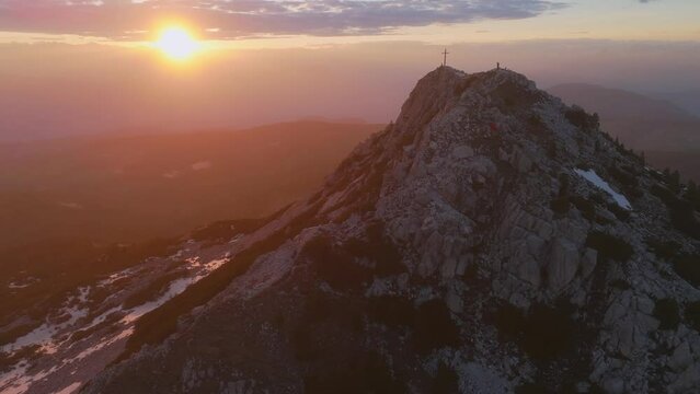 A stunning aerial view of Corno Bianco mountain at sunset with a cross at the peak