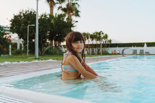 girl in outdoor swimming pool on summer vacation