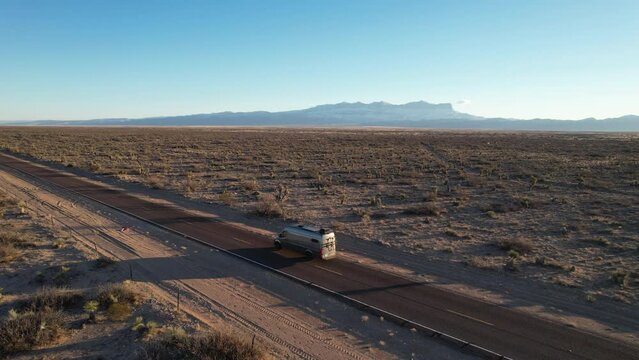 RV camper van drives along open lonely desert road, Dell City, Texas