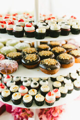 Iced donut and strawberry cupcake display at dessert table