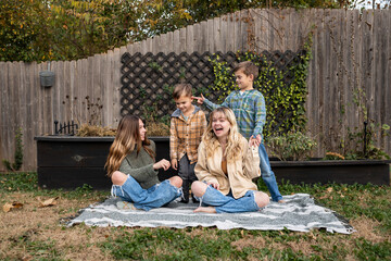 Happy siblings enjoying a  playful moment in backyard on an autumn day © Cavan