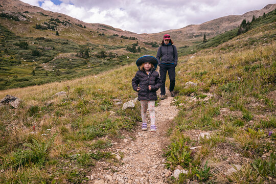 Mother and daughter hiking on scenic mountain trail