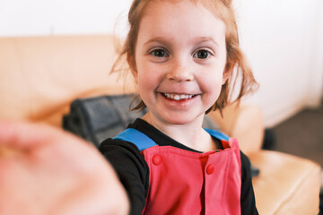 Smiling young girl reaching out in a playful moment