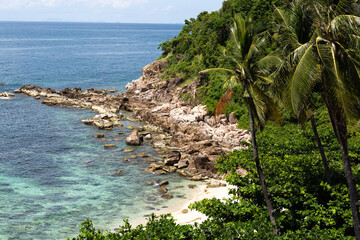 Leaning palm trees and idyllic tropical beach in Thailand