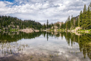 Beautiful mountain lake with reflection surrounded by trees and