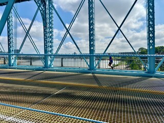 Person jogging on Roebling Bridge in Cincinnati, OH with river view