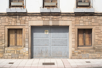 Puerta de garaje en fachada vieja de calle urbana 