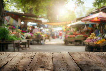 A wooden stall in the foreground with a blurred background of an open-air market. The background includes various vendors selling fresh produce, flowers, and handmade goods.