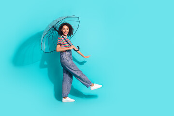 Photo profile side of positive girl with umbrella walking isolated cyan color background