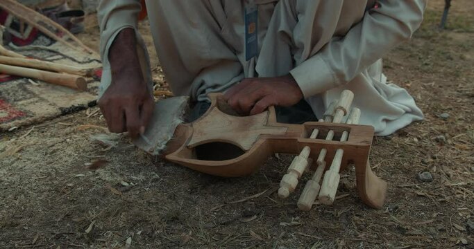 Closeup footage of a person making rabab musical instrument from wood