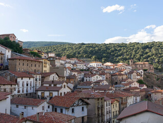 Fototapeta premium A small town with many houses and a church. The houses are mostly white and the roofs are red.