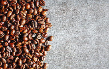 Overhead view of gray backdrop representing halves of dark brown coffee beans and Textured...