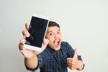 image of asian man holding phone, isolated on yellow background.