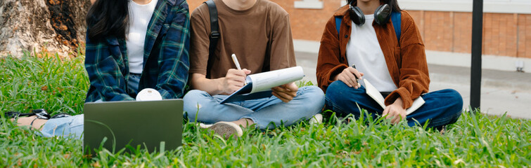 Young Asian People college students and a female student group work at the campus park in morning...