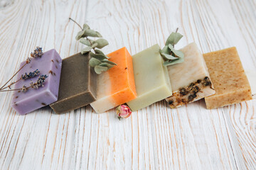 Handmade soap from natural ingredients, various herbs on a white wooded background. Concept of...