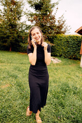 Young woman chatting on her cell phone outdoors in the garden