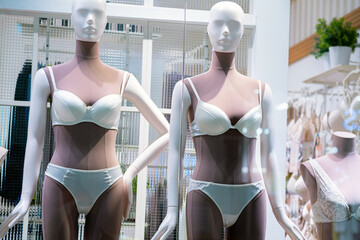 A display of mannequins in a store window, showcasing the latest fashion trends.