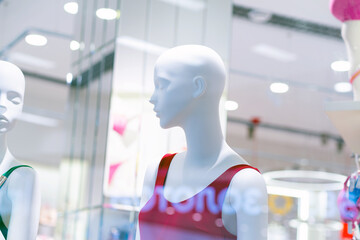 A display of mannequins in a store window, showcasing the latest fashion trends.