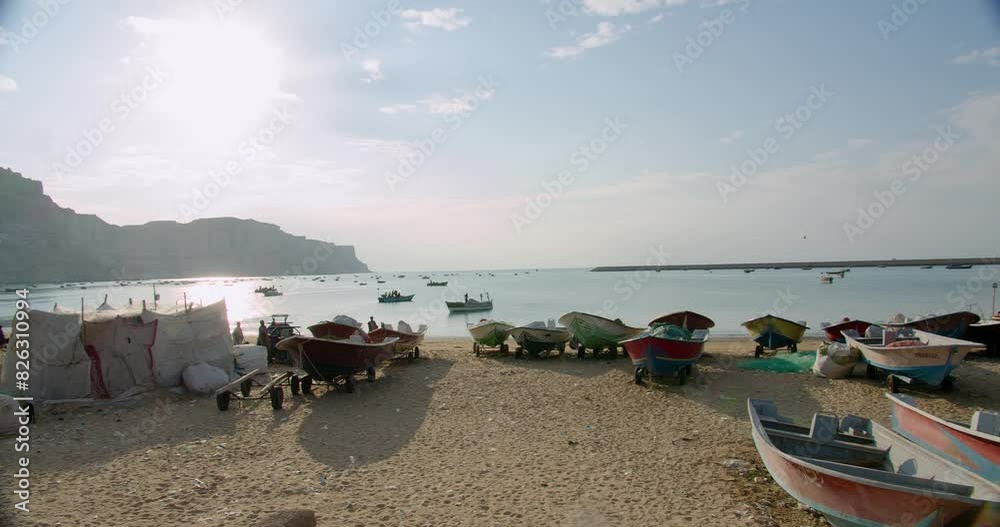 Wall mural Footage revealing many of fishing boats on Gwadar Beach on a sunny day with sea in background